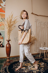 一位漂亮的金发女子的画像日前在一家女装服装店的广告中出现，这家店穿着长裤和T恤衫，手里拿着一个现代环保纸袋