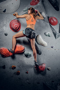 在攀岩墙上爬的运动女性 