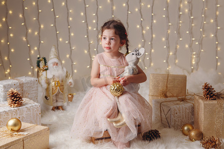 白人白种女孩的肖像与棕色的眼睛坐在玩具庆祝圣诞节或新年假期