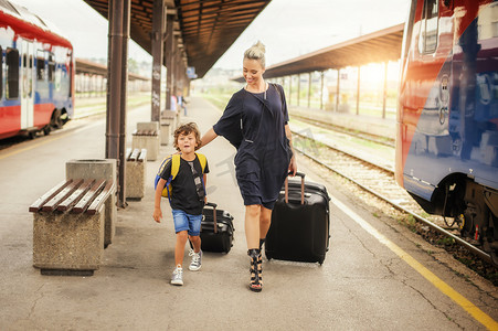 可爱的小男孩和母亲在火车站