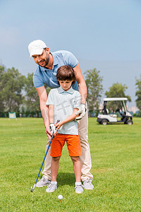 man teaching his son to play golf