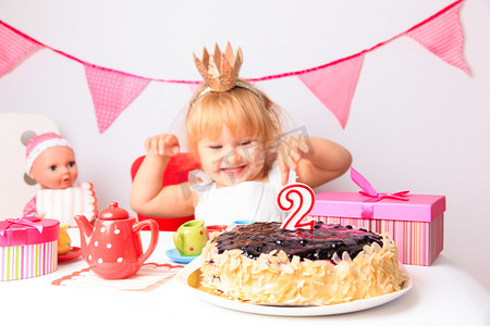 装饰可爱皇冠摄影照片_快乐可爱的小女孩在生日聚会上