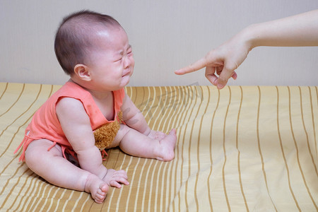 生气大骂摄影照片_亚洲婴儿的哭声而责骂的母亲 