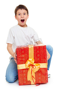 红色金色商务背景摄影照片_男孩与红色礼品盒和金弓-假日对象概念隔离