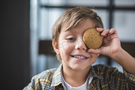 食物可爱风格摄影照片_微笑的小男孩与曲奇饼