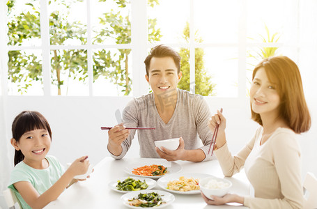 幸福的亚洲年轻家庭享用他们的晚餐