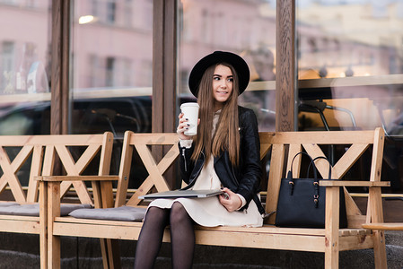 长木凳摄影照片_Trendy woman resting after work on net-book