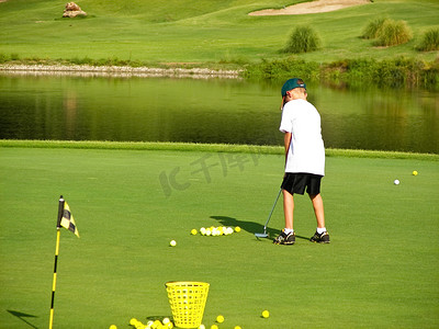 小男孩打高尔夫球