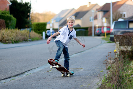 小男孩学着在滑板上保持平衡