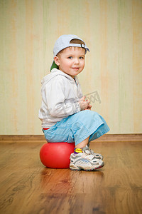 男孩坐在一个球上