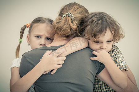 孩子抱妈妈摄影照片_伤心的孩子抱着他的母亲