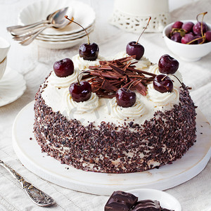 黑森林蛋糕、 Schwarzwald 馅饼、 白色木制背景上的黑巧克力和樱桃甜点.