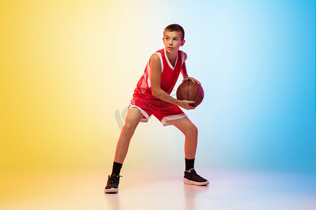 渐变活动摄影照片_具有渐变背景的年轻篮球运动员的全长肖像