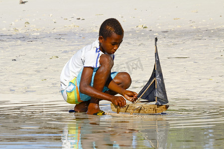 可怜的马达加斯加男孩玩手工制作的船