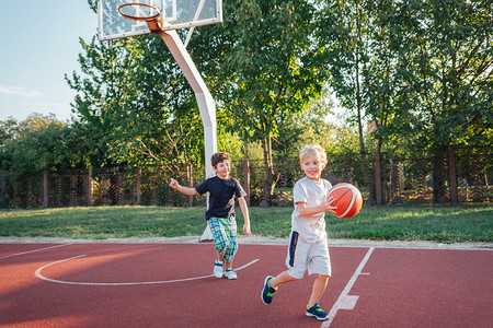 两个小篮球运动员在户外球场训练.
