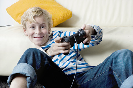 年轻男孩玩 playstation 在家.