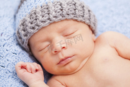 刚出生的婴儿睡在蓝色的毯子上