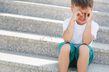 The boy sitting on the stairs in the underpass