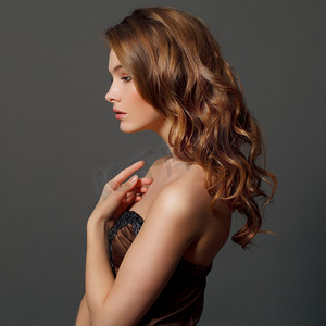 女士商务发型摄影照片_美女模型与长期健康的波浪式头发和完美的妆