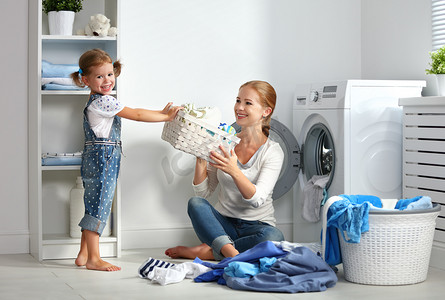 家庭的母亲和孩子在洗衣房附近纸的小帮手