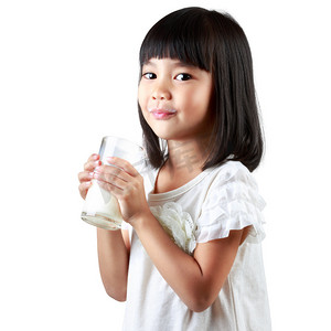捧着杯子摄影照片_快乐的小亚洲女孩捧着一杯牛奶