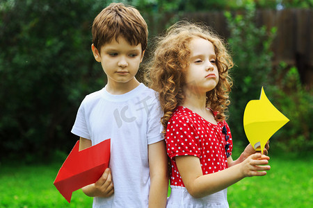 两个箭头指向摄影照片_孩子在夏天举行颜色箭头指向右和左，