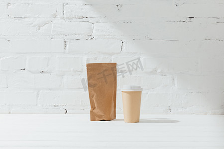 咖啡和一次性杯子的纸包前视图