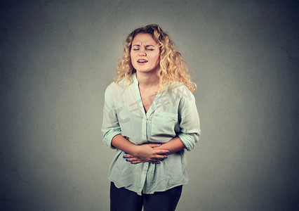 young woman hands on stomach having bad aches pain