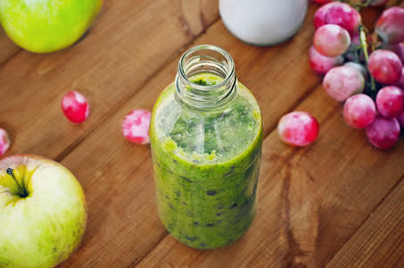 Fresh homemade smoothie with kiwi, bananas, grapes, apple on wooden table