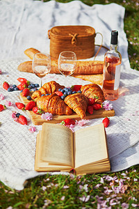 美丽的野餐与玫瑰酒，法国羊角面包和新鲜的浆果