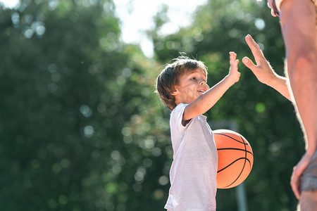 开心男孩摄影照片_在篮球场上带球的快乐男孩
