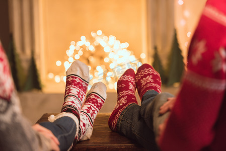 圣诞壁炉摄影照片_夫妇在壁炉旁的针织袜子