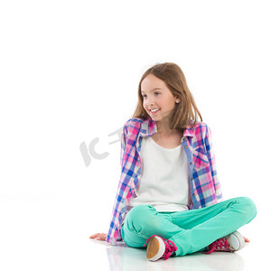小女孩微笑着坐在一起的双腿交叉