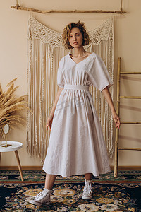 一位漂亮的金发女子的画像在一家身着浅白连衣裙的女装商店登广告
