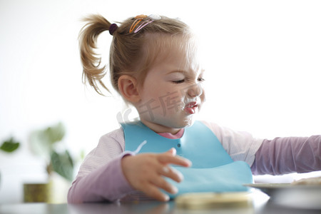 小女孩幼儿摘她的食物，做鬼脸