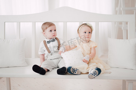 two babies wedding - boy and girl dressed as bride and groom