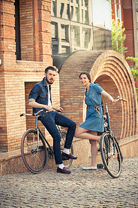 年轻夫妇坐在一辆自行车市对面