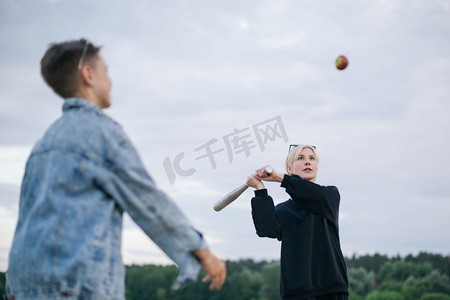 游戏光线摄影照片_母亲和儿子在户外打棒球的选择性焦点