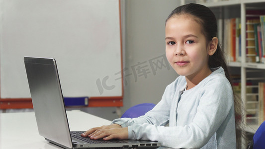 家庭教育家庭教育摄影照片_快乐美丽的亚洲小女孩使用笔记本电脑微笑
