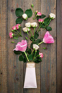 玫瑰摄影照片_在木头上的鲜花和化妆品管 