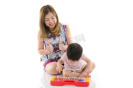 可爱的母亲教她的儿子小孩玩电动玩具钢琴 