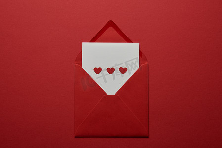 白色信件的顶部看法与心脏在信封在红色背景