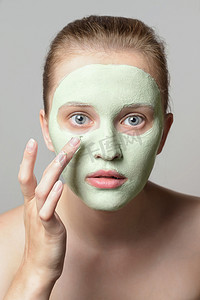 自然呵护摄影照片_女孩脸上的绿色奶油.