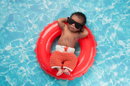 夏天游泳圈摄影照片_漂浮在游泳圈上的初生男婴