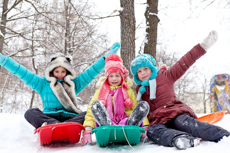 雪摄影照片_性格开朗快乐的孩子们坐雪橇冬季的一天