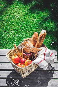 带杏果酱的水果、面包和罐子的野餐篮