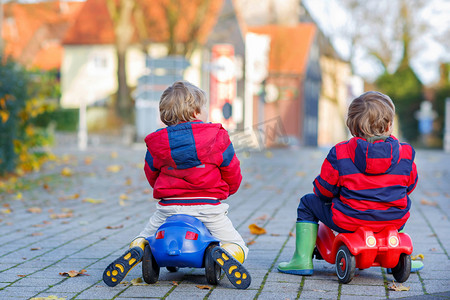 两个快乐的朋友男孩在玩彩色玩具车、 户外