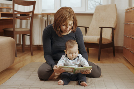 读本书摄影照片_母亲与她的孩子读一本书