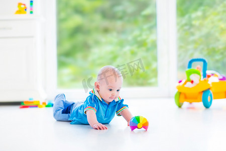 可爱的宝宝男孩玩耍着五颜六色的球、 玩具车