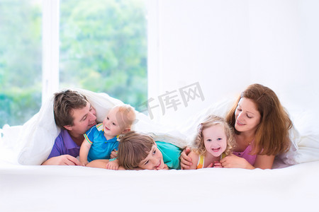 粉红睡衣摄影照片_幸福的大家庭，在卧室里